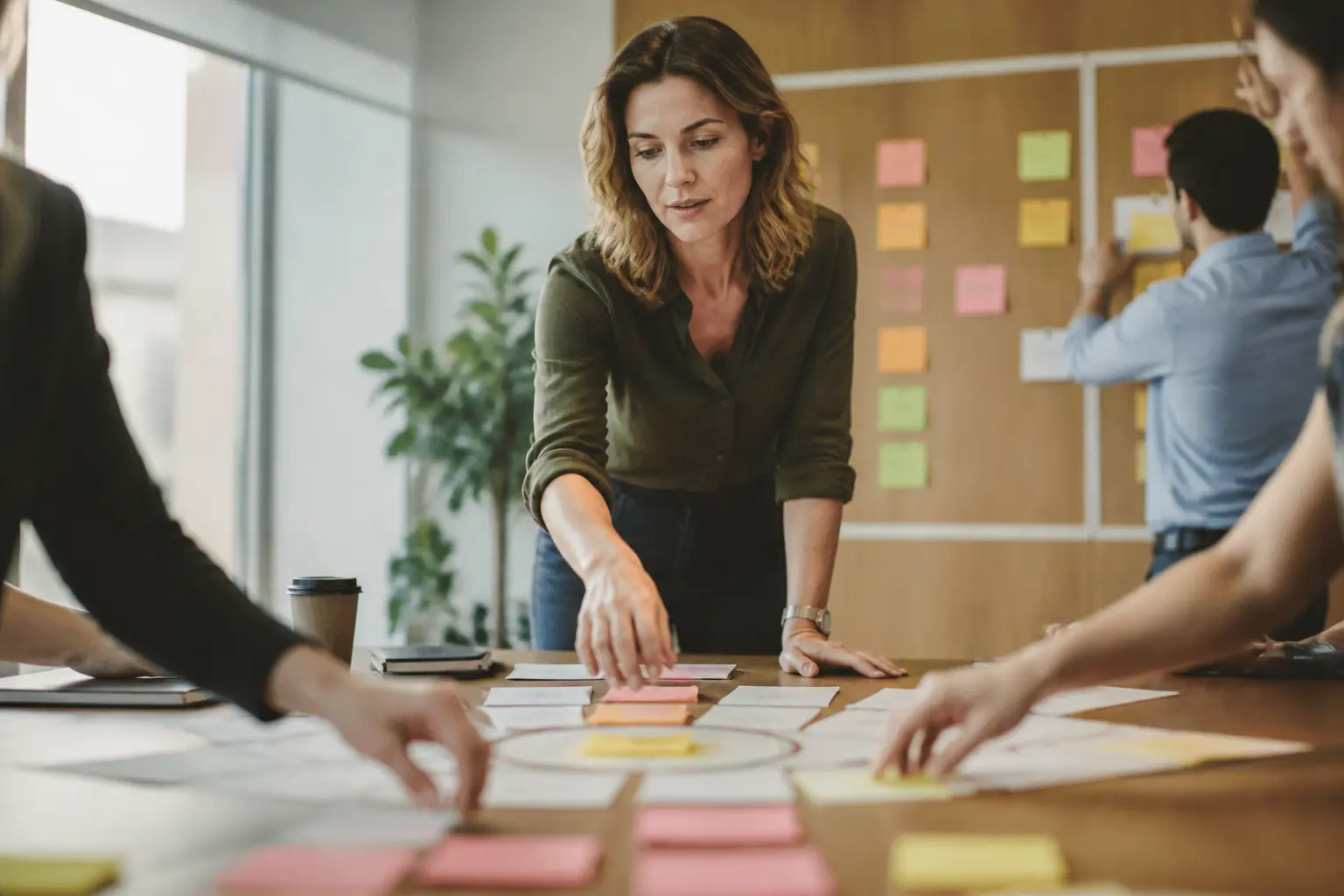 Manager en réunion, priorisation des tâches sur tableau kanban avec post-it, ambiance de bureau moderne et concentrée